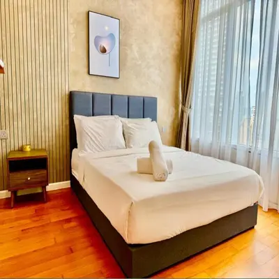 a bed in a bedroom with a large window at Sky suites klcc by Elham in Kuala Lumpur
