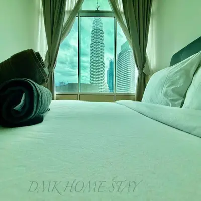 a bedroom with a white bed with a view of a skyscraper at Sky suites klcc by Elham in Kuala Lumpur
