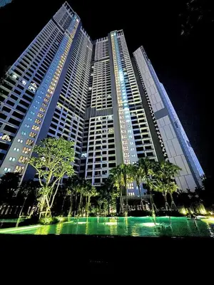 a large building with palm trees in front of it at Agile Residence Service Suites Bukit Bintang KL in Kuala Lumpur