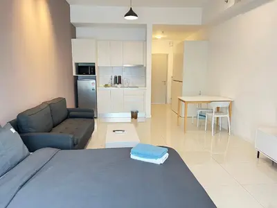 a living room and kitchen with a couch and a table at Chambers Auroa Luxury Suites KLCC in Kuala Lumpur