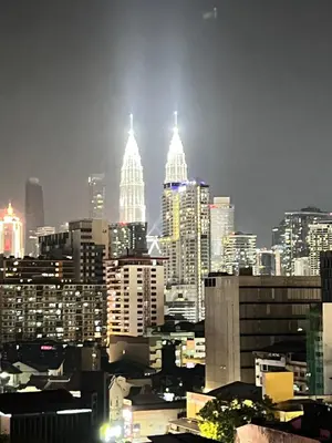 a view of a city skyline at night at Chambers Auroa Luxury Suites KLCC in Kuala Lumpur