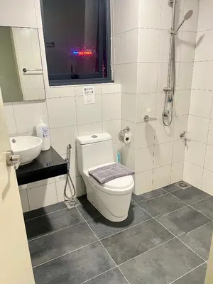 a bathroom with a toilet and a sink and a shower at Chambers Auroa Luxury Suites KLCC in Kuala Lumpur
