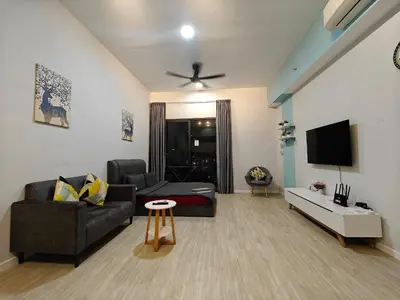 a living room with a couch and a tv at Chambers Auroa Luxury Suites KLCC in Kuala Lumpur