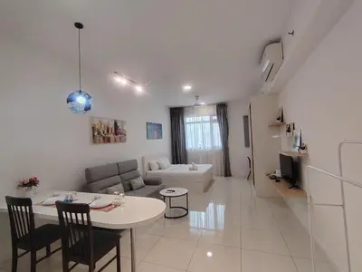 a white living room with a table and a couch at Chambers Skypool KLCC in Kuala Lumpur