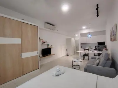 a white living room with a couch and a kitchen at Chambers Skypool KLCC in Kuala Lumpur