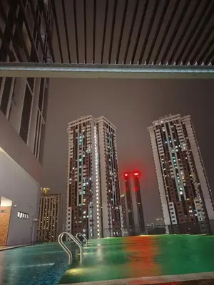 a view of a city at night with tall buildings at Chambers Skypool KLCC in Kuala Lumpur