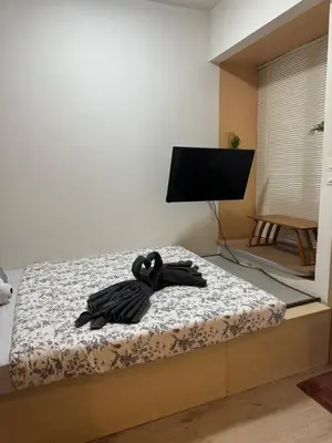 a swan robe sitting on a bed in a room at INFINITUM suites KLCC , infinity pool 360 view in Kuala Lumpur