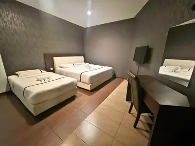 a hotel room with two beds and a desk at Seeds Hotel Cheras Permaisuri in Kuala Lumpur