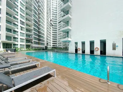 a large swimming pool with chairs and buildings at Comfy Arte Plus Ampang KL City 8 Pax-3BR-2CP in Kuala Lumpur
