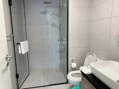 a bathroom with a shower with a toilet and a sink at The Atrium at Jalan Ampang by OKBnB - Classy 3Bedroom Family Suite nearby KLCC , TRX and Pavilion KL in Kuala Lumpur