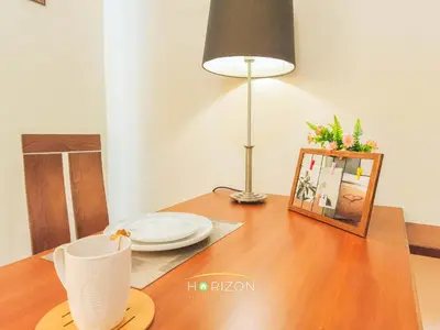 a table with a plate and a lamp and a picture at MayTower by Horizon Homes in Kuala Lumpur