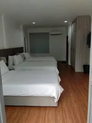 a bedroom with two white beds and a wooden floor at Kl Gateway in Kuala Lumpur