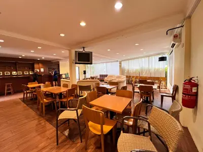 a restaurant with tables and chairs and a tv on the wall at Kl Gateway in Kuala Lumpur