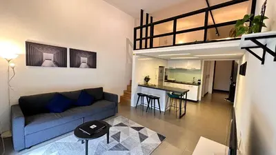 a living room with a blue couch and a kitchen at The Establishment Bangsar #23a by Ouki in Kuala Lumpur