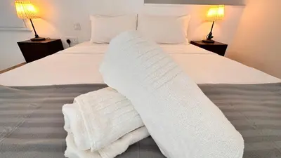 a bed with white blankets and pillows on it at The Establishment Bangsar #23a by Ouki in Kuala Lumpur