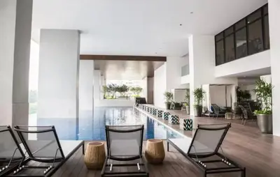a room with two chairs and a swimming pool at The Establishment Bangsar #2216 by Ouki in Kuala Lumpur