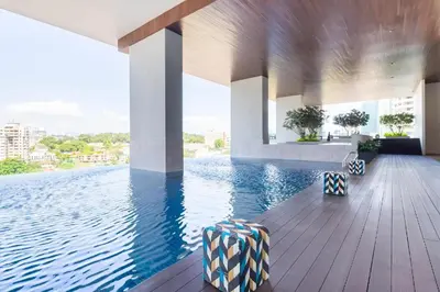 a swimming pool with two chairs on a wooden deck at The Establishment Bangsar #29 by Ouki in Kuala Lumpur