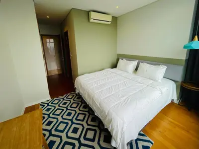 a bedroom with a large white bed and a rug at Ludy House in Kuala Lumpur