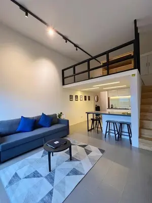 a living room with a blue couch and a table at The Establishment Bangsar #2222 by Ouki in Kuala Lumpur