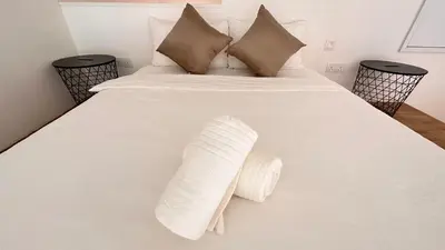 a bed with white sheets and pillows on it at The Establishment Bangsar #2222 by Ouki in Kuala Lumpur