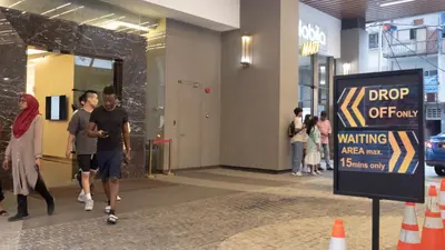 a group of people walking inside of a building at Axon Residences KLCC - Premium Suites in Kuala Lumpur