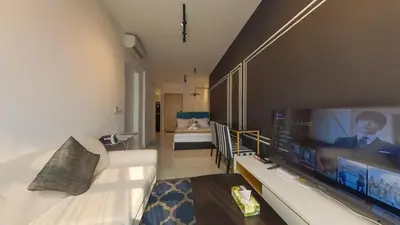 a living room with a couch and a large tv at Axon Residences KLCC - Premium Suites in Kuala Lumpur