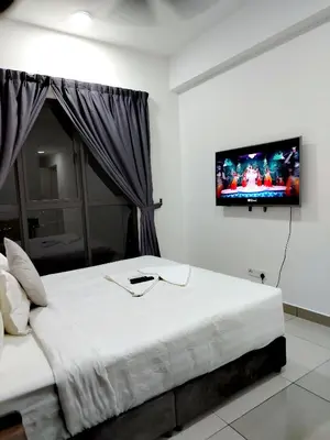 a bedroom with a bed with a tv on the wall at TRION Luxury City Suites Near KLCC & TRX in Kuala Lumpur