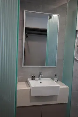 a bathroom with a white sink and a mirror at Rivera City, KL Sentral Studio Apartment in Kuala Lumpur