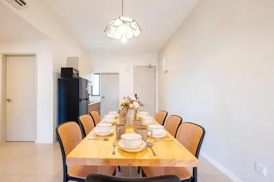 a dining room with a table with chairs and a kitchen at Kids Friendly Homestay at Riana Dutamas in Kuala Lumpur