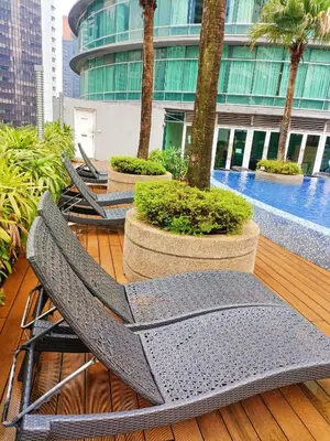 a couple of chairs sitting on a deck with trees at Vortex Apartment Near By Klcc in Kuala Lumpur