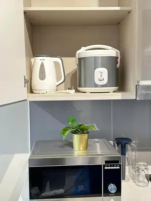 a microwave on a shelf with a plant on it at AGILE SKY HOME Near Pavilion with TRX and GOLF View Including Swimming Pool in Kuala Lumpur