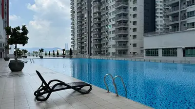a swimming pool with a chair next to some buildings at Razak City Fully Air-Con Suite Sungai Besi Kuala Lumpur 57100 in Kuala Lumpur
