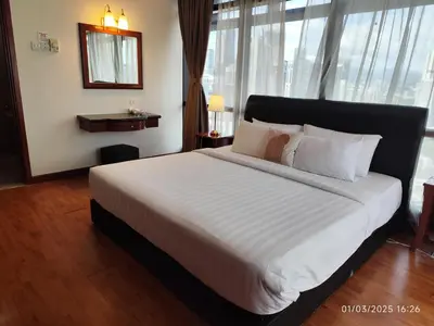 a bedroom with a large white bed with a large window at The Marvelous Suites at Times Square Kuala Lumpur in Kuala Lumpur