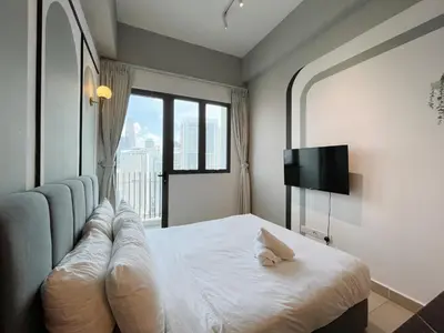 a bedroom with a bed and a tv and a window at The Colony Infinitum By Couple Stay in Kuala Lumpur