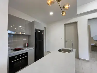 a kitchen with a white counter and a black refrigerator at Trion KL By Couple stay in Kuala Lumpur