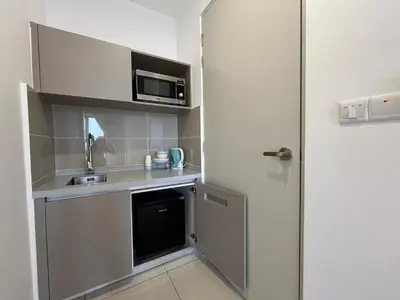 a small kitchen with a sink and a microwave at Trion KL By Couple stay in Kuala Lumpur