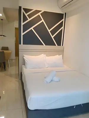 a bed in a hotel room with a headboard at Colony by infinitum KLCC in Kuala Lumpur