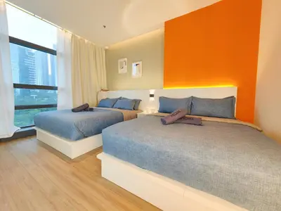 a bedroom with two beds and an orange wall at The Aspire - Bangsar Trade Centre in Kuala Lumpur