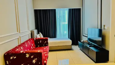 a hotel room with a bed and a red chair at AXON Residence Near TRX & Pavilion KL in Kuala Lumpur