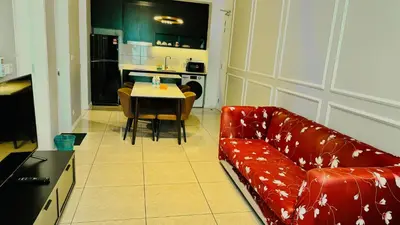 a living room with a red couch and a table at AXON Residence Near TRX & Pavilion KL in Kuala Lumpur