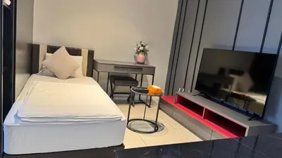 a bedroom with a bed and a desk and a television at AXON Residence Near TRX & Pavilion KL in Kuala Lumpur