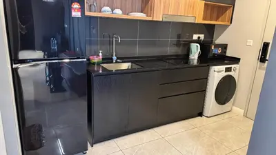 a kitchen with a sink and a washing machine at AXON Residence Near TRX & Pavilion KL in Kuala Lumpur