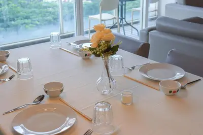 a table with plates and a vase of flowers on it at Bintang Goldhill, 5M to TRX in Kuala Lumpur