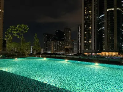 a large swimming pool with a city skyline at night at Cozy Urban Retreat in the Heart of the Bangsar in Kuala Lumpur
