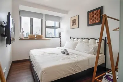 a bedroom with a white bed with a wooden frame at Cozy Studio l Riveria City l 1km to KL Sentral in Kuala Lumpur