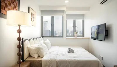 a bedroom with a bed with a lamp and windows at Cozy Studio l Riveria City l 1km to KL Sentral in Kuala Lumpur