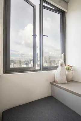 a rabbit sitting on a window sill looking out at the city at Cozy Studio l Riveria City l 1km to KL Sentral in Kuala Lumpur