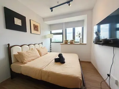 a bedroom with a large bed with a black bag on it at Cozy Studio l Riveria City l 1km to KL Sentral in Kuala Lumpur