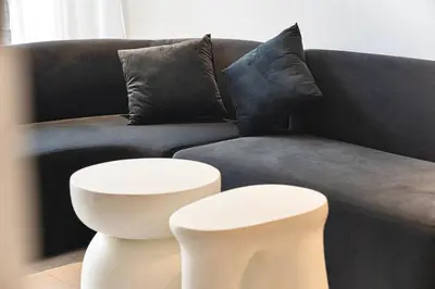a living room with a couch and two stools at Cozy Unit l Agile BB l 5min walk to TRX Pavilion in Kuala Lumpur