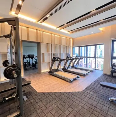 a gym with a row of treadmills and machines at Cozy Unit l Agile BB l 5min walk to TRX Pavilion in Kuala Lumpur